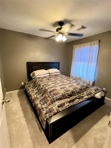 a bed sitting in a bedroom next to a window