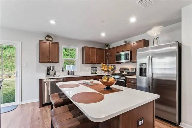 a kitchen with refrigerator and chairs