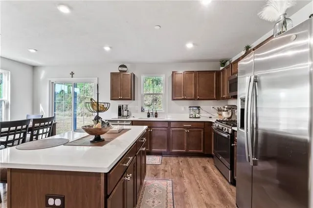 a kitchen with kitchen island granite countertop a sink stove and refrigerator