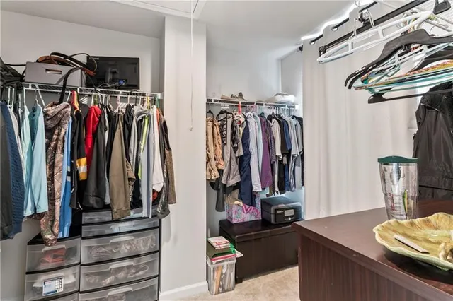 a view of walk in closet with clothes
