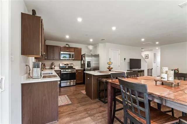 a large kitchen with kitchen island granite countertop a sink a stove and chairs