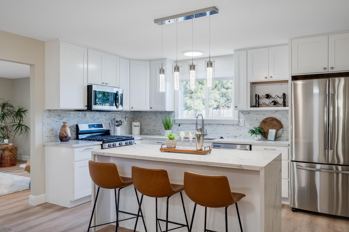 3173 Shuler Circle Marina, CA 93933 - Photo 16 of 55 a kitchen with stainless steel appliances a stove a sink refrigerator and white cabinets with wooden floor