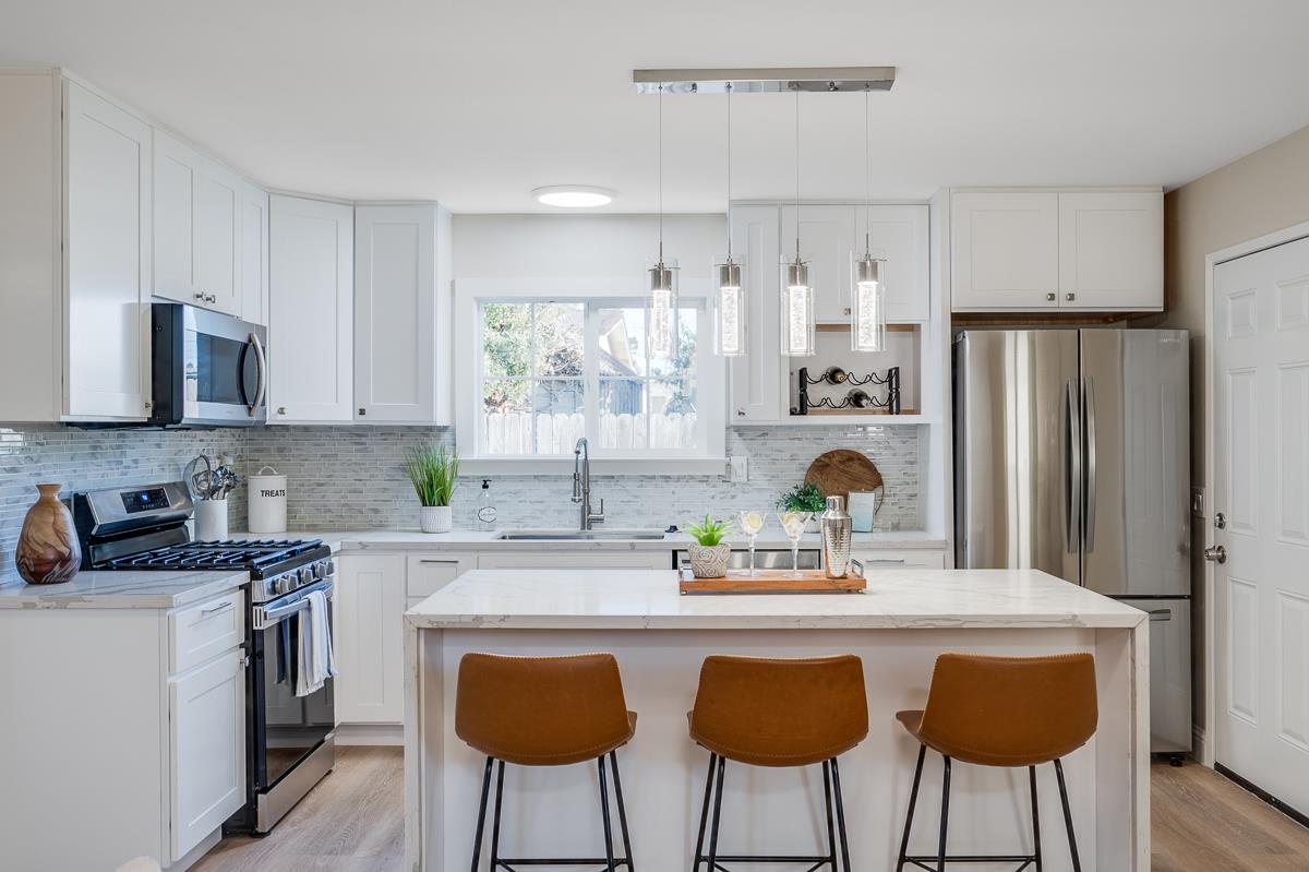 3173 Shuler Circle Marina, CA 93933 - Photo 17 of 55 a kitchen with stainless steel appliances a dining table chairs refrigerator and sink