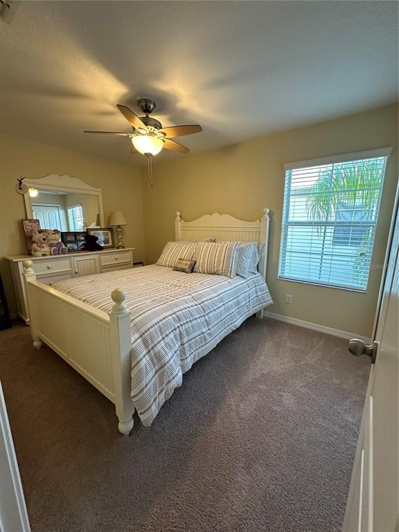 9476 Trumpet Vine Loop Trinity, FL 34655 - Photo 12 of 19 a bedroom with a bed and a chandelier