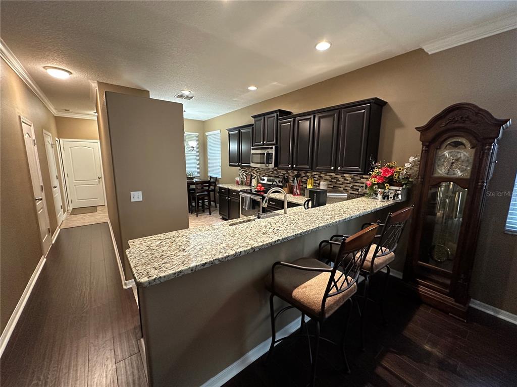 9476 Trumpet Vine Loop Trinity, FL 34655 - Photo 6 of 19 a kitchen with a table chairs refrigerator and microwave