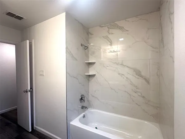 a bathroom with a bathtub and shower