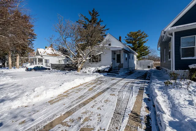 a view of a house with a yard covered in snow