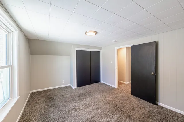 an empty room with windows and closet