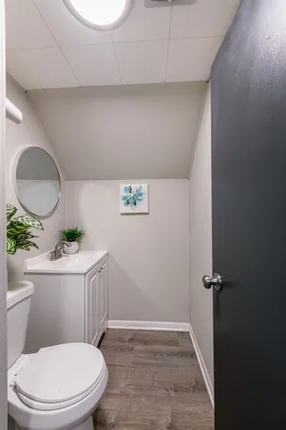 a white toilet sitting next to a bathroom sink and a mirror