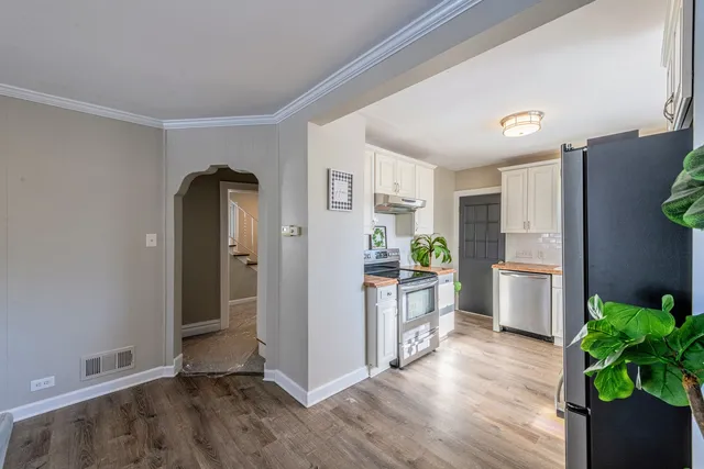 a kitchen with a refrigerator and a stove top oven