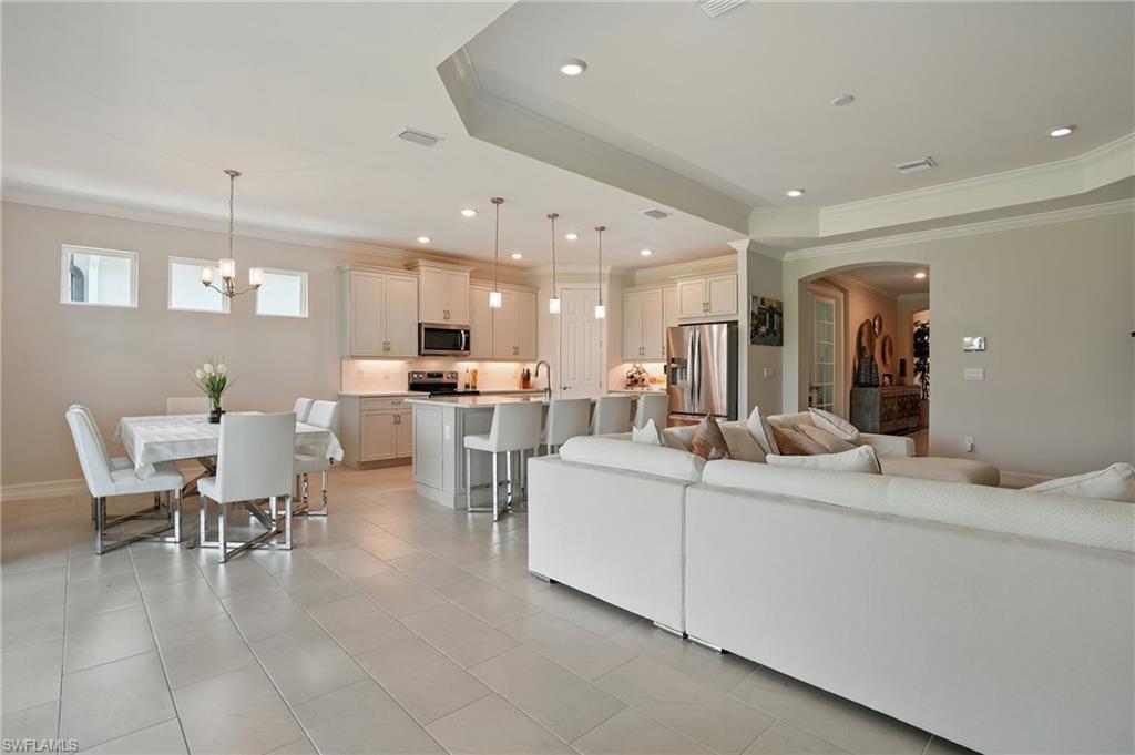 28165 Captiva Shell Loop Bonita Springs, FL 34135 - Photo 38 of 38 Kitchen with appliances with stainless steel finishes, light tile patterned floors, an island with sink, open floor plan, and hanging light fixtures