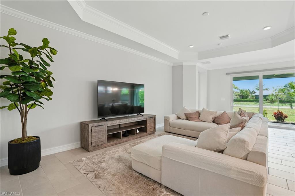 28165 Captiva Shell Loop Bonita Springs, FL 34135 - Photo 11 of 38 Kitchen with appliances with stainless steel finishes, arched walkways, backsplash, a kitchen breakfast bar, and a center island with sink