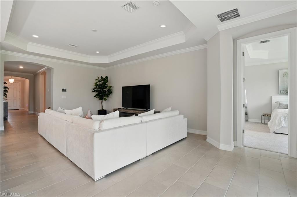 28165 Captiva Shell Loop Bonita Springs, FL 34135 - Photo 9 of 38 Living room with a tray ceiling, crown molding, and tile patterned flooring