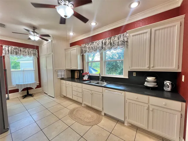 a large kitchen with a large window appliances and cabinets