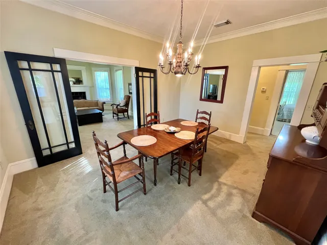 a view of a dining room with furniture and a chandelier