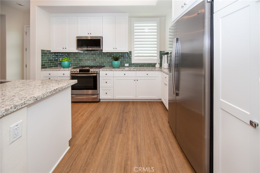 27466 Mercantile Court, Unit 101 Valencia, CA 91381 - Photo 4 of 21 a kitchen with a sink and a refrigerator