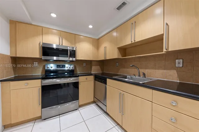 a kitchen with stainless steel appliances granite countertop a sink and a stove