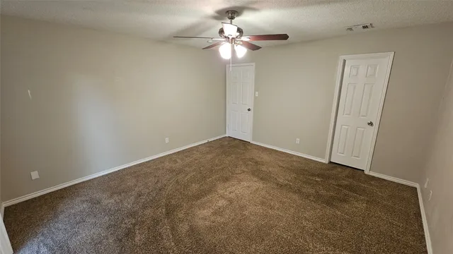 an empty room with a chandelier fan