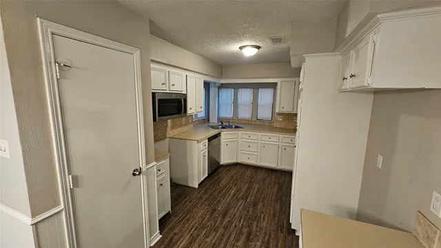 a kitchen with white cabinets and white appliances