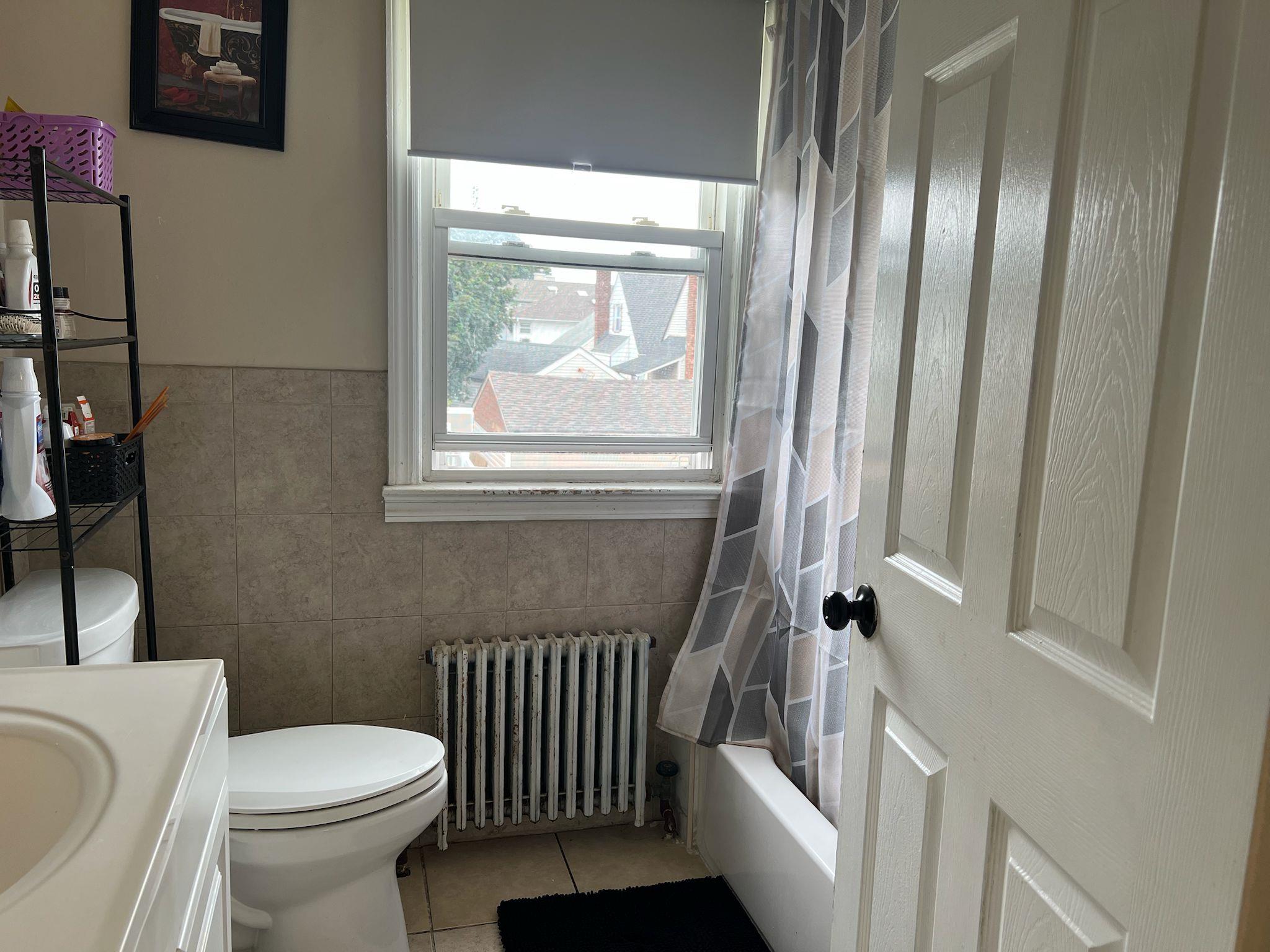 182 Long Beach Road Hempstead, NY 11550 - Photo 17 of 24 a white toilet sitting next to a bathroom sink