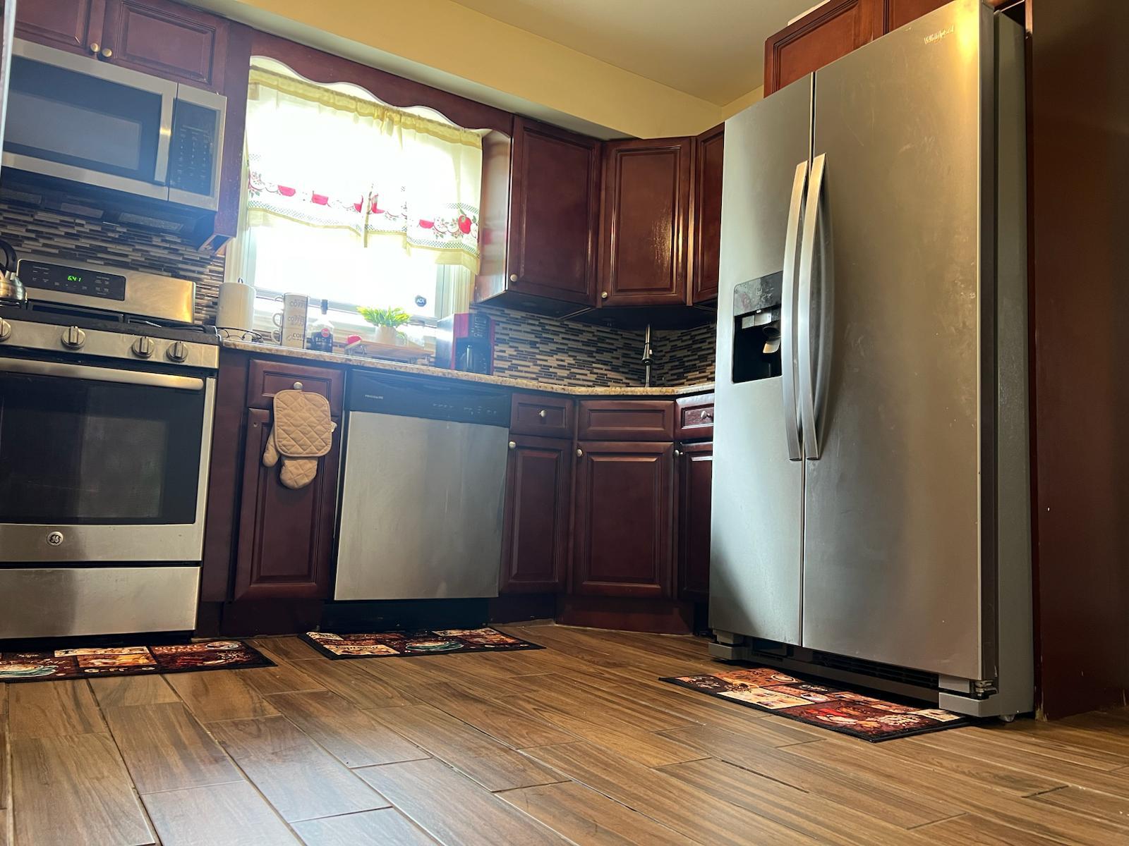 182 Long Beach Road Hempstead, NY 11550 - Photo 10 of 24 a kitchen with stainless steel appliances granite countertop a refrigerator and a stove