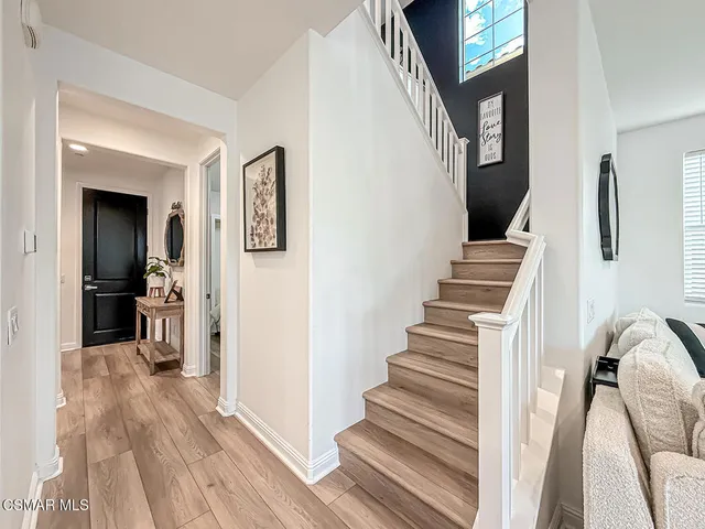 a large white room with kitchen island a sink a counter space and stainless steel appliances