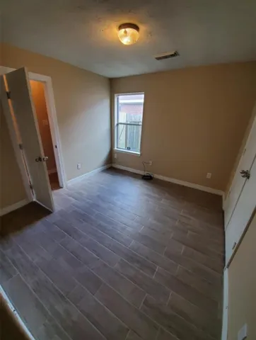 an empty room with wooden floor and a window