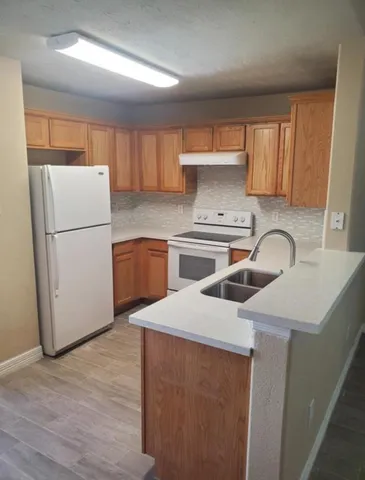 a kitchen with a sink a refrigerator and a stove top oven