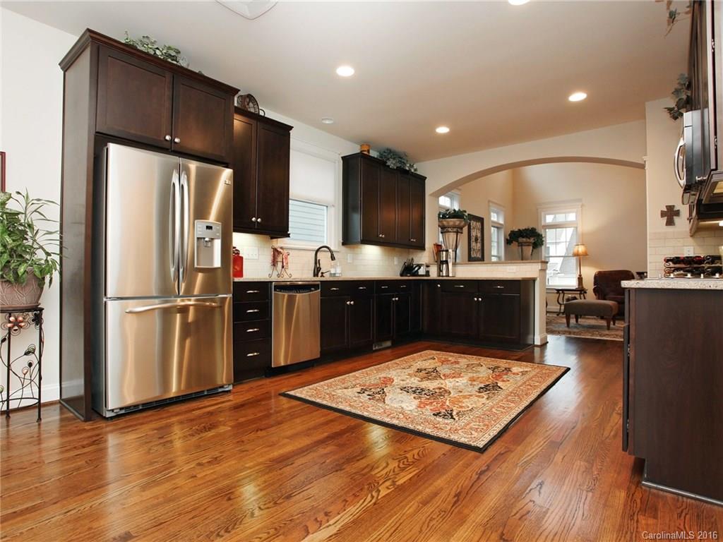 660 Revival Row Fort Mill, SC 29708 - Photo 11 of 24 a kitchen with stainless steel appliances granite countertop a refrigerator oven a sink dishwasher and a stove with wooden floor