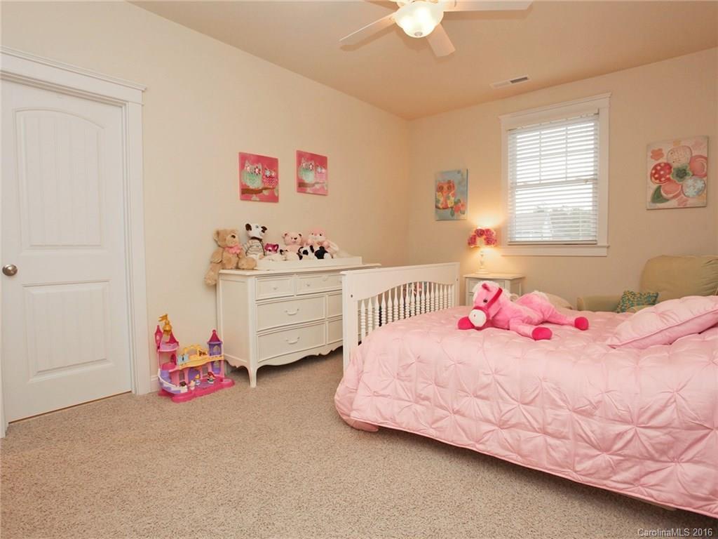 660 Revival Row Fort Mill, SC 29708 - Photo 23 of 24 a bedroom with a bed and a chandelier