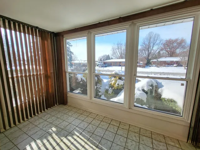 an empty room with windows and fireplace