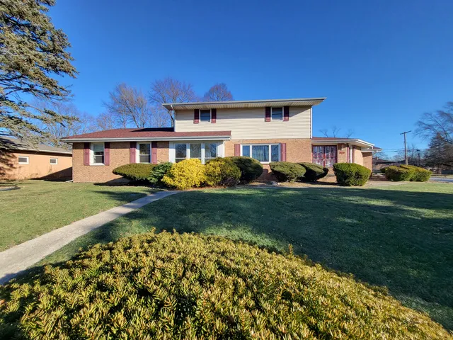 a view of a house with backyard and sitting area