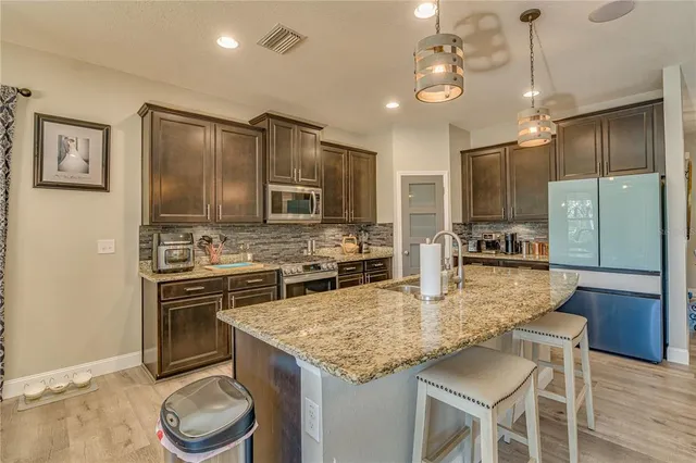 a kitchen with kitchen island granite countertop a sink stove and refrigerator