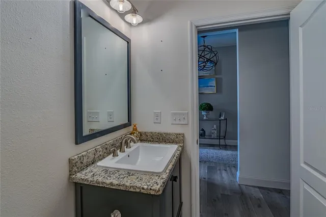 a bathroom with a granite countertop sink and a mirror