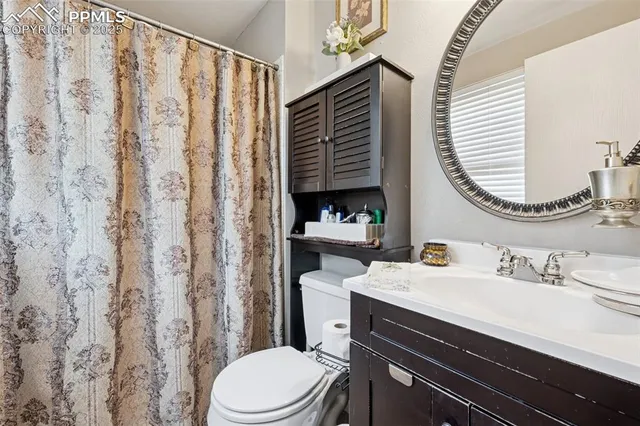 a bathroom with a sink a toilet and shower curtain