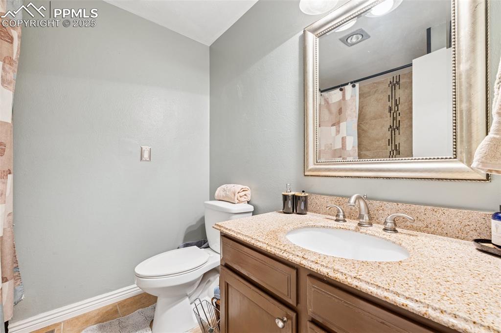 5560 Constitution Avenue Colorado Springs, CO 80917 - Photo 20 of 30 a bathroom with a granite countertop sink toilet and mirror