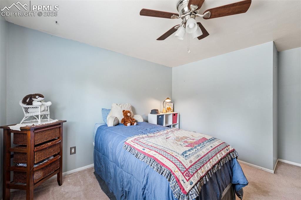 5560 Constitution Avenue Colorado Springs, CO 80917 - Photo 22 of 30 a bed room with a bed and a chandelier