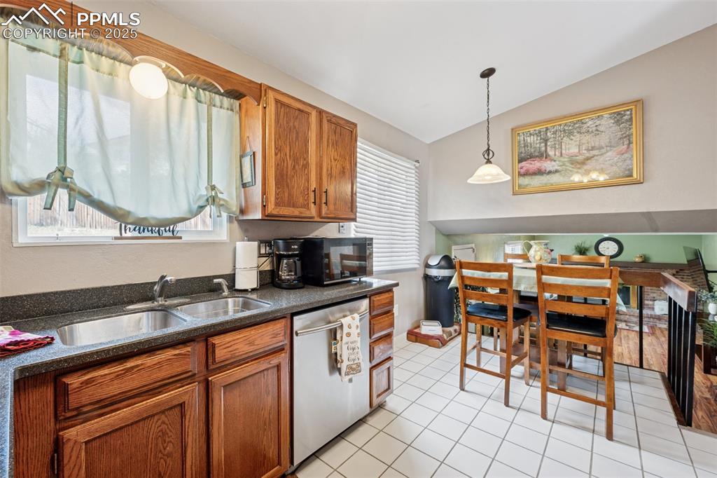 5560 Constitution Avenue Colorado Springs, CO 80917 - Photo 7 of 30 a kitchen with stainless steel appliances kitchen island granite countertop a sink and cabinets