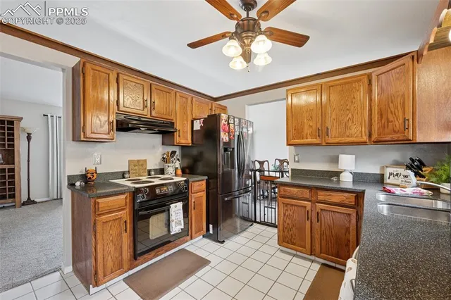 a kitchen with stainless steel appliances granite countertop a stove top oven a sink dishwasher and cabinets with wooden floor