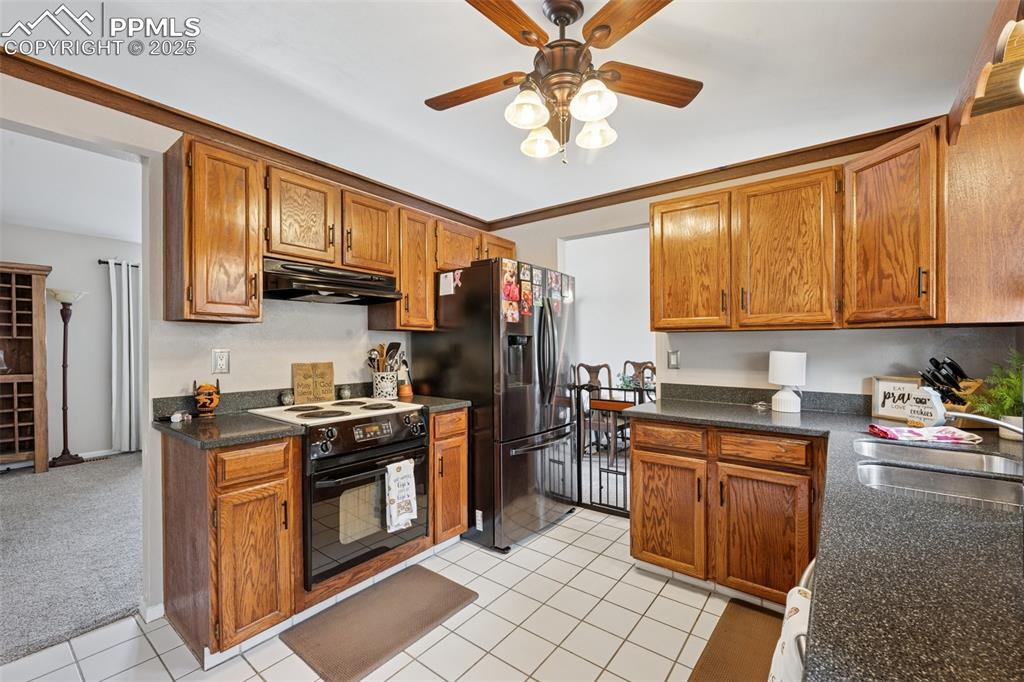 5560 Constitution Avenue Colorado Springs, CO 80917 - Photo 9 of 30 a kitchen with stainless steel appliances granite countertop a stove top oven a sink dishwasher and cabinets with wooden floor