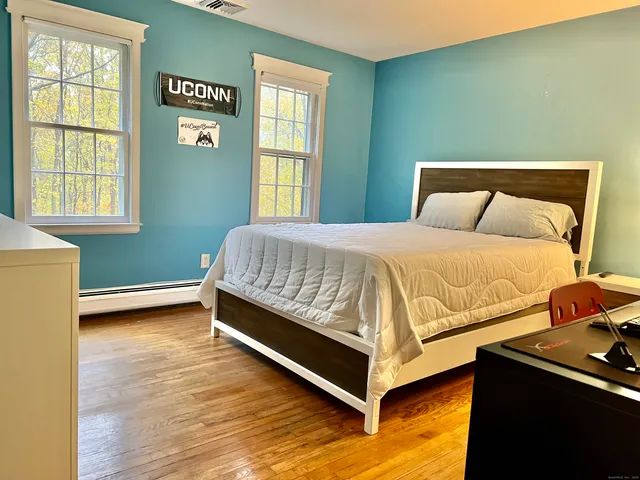 a bedroom with a bed and windows