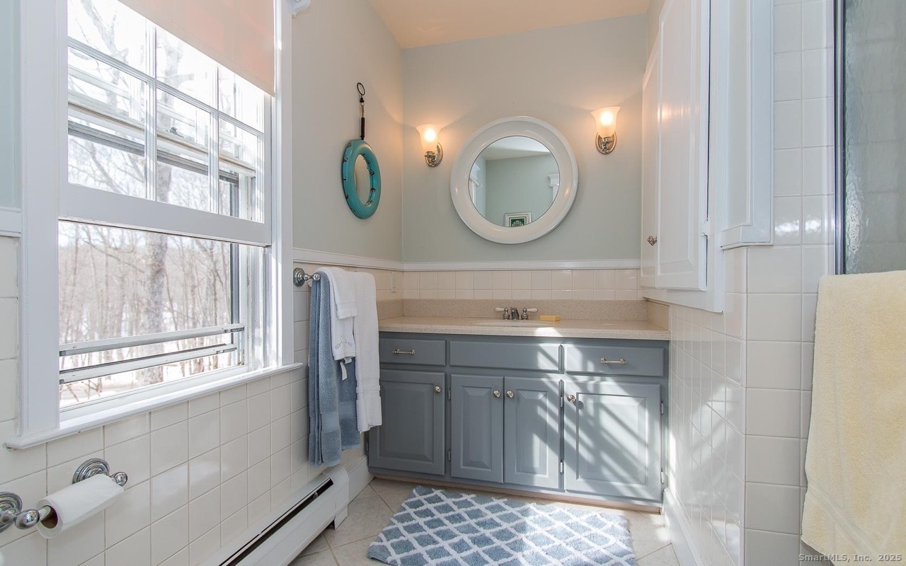 61 High Rock Road Newtown, CT 06482 - Photo 10 of 14 a bathroom with a sink a vanity and a large mirror