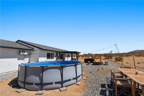 a roof deck with table and chairs a barbeque with wooden floor and fence