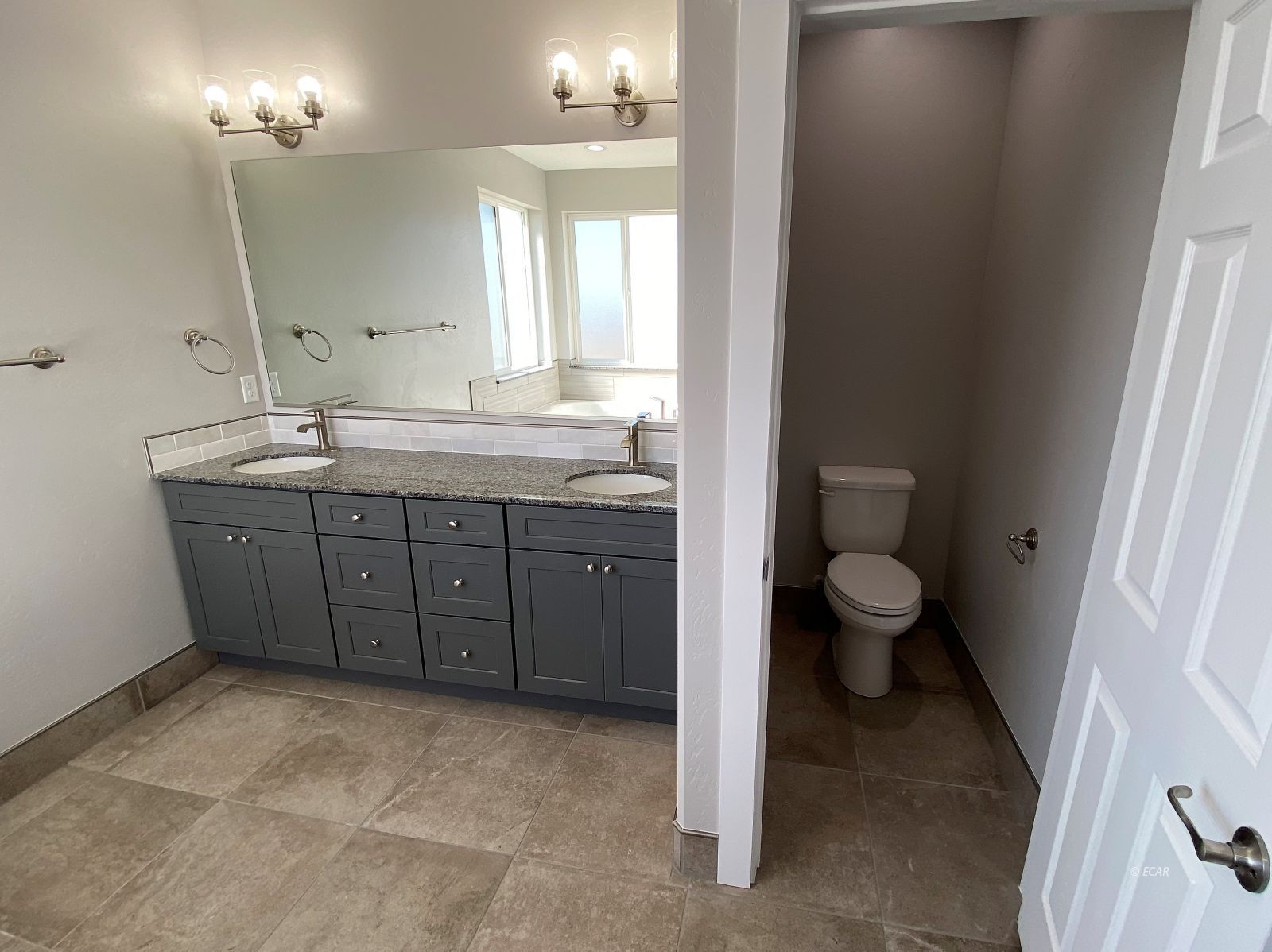 269 Sun Vly Road Spring Creek, NV 89815 - Photo 19 of 25 a spacious bathroom with a granite countertop sink a toilet and a mirror