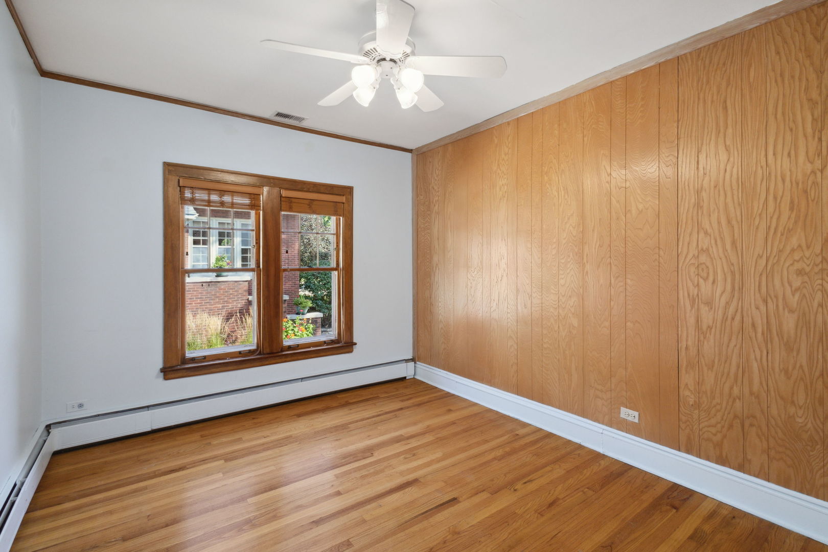 310 Bartram Road Riverside, IL 60546 - Photo 9 of 25 an empty room with wooden floor chandelier fan and windows
