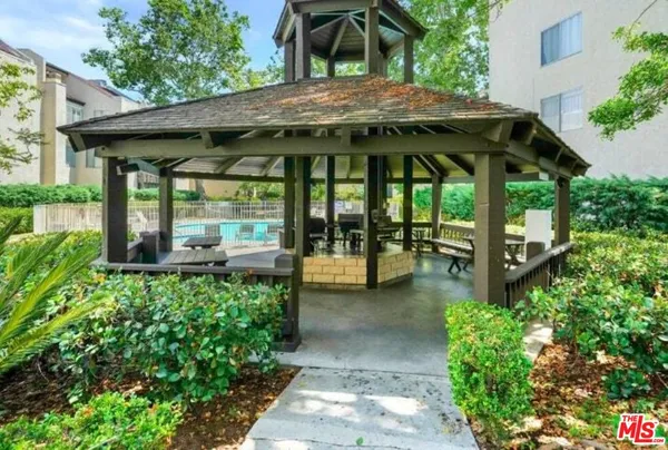a view of a patio with table and chairs potted plants with wooden floor and fence