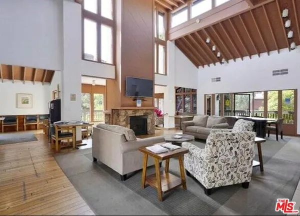 a living room with furniture a fireplace and a large window