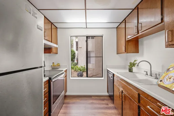 a kitchen with stainless steel appliances a sink window and cabinets