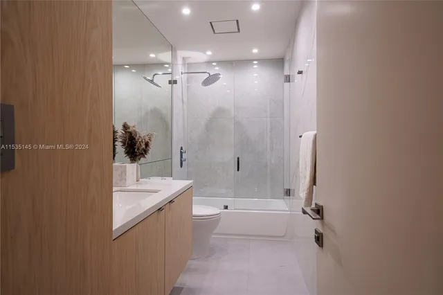 a bathroom with a sink a toilet and mirror