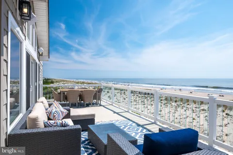 a view of roof deck with seating space and ocean view